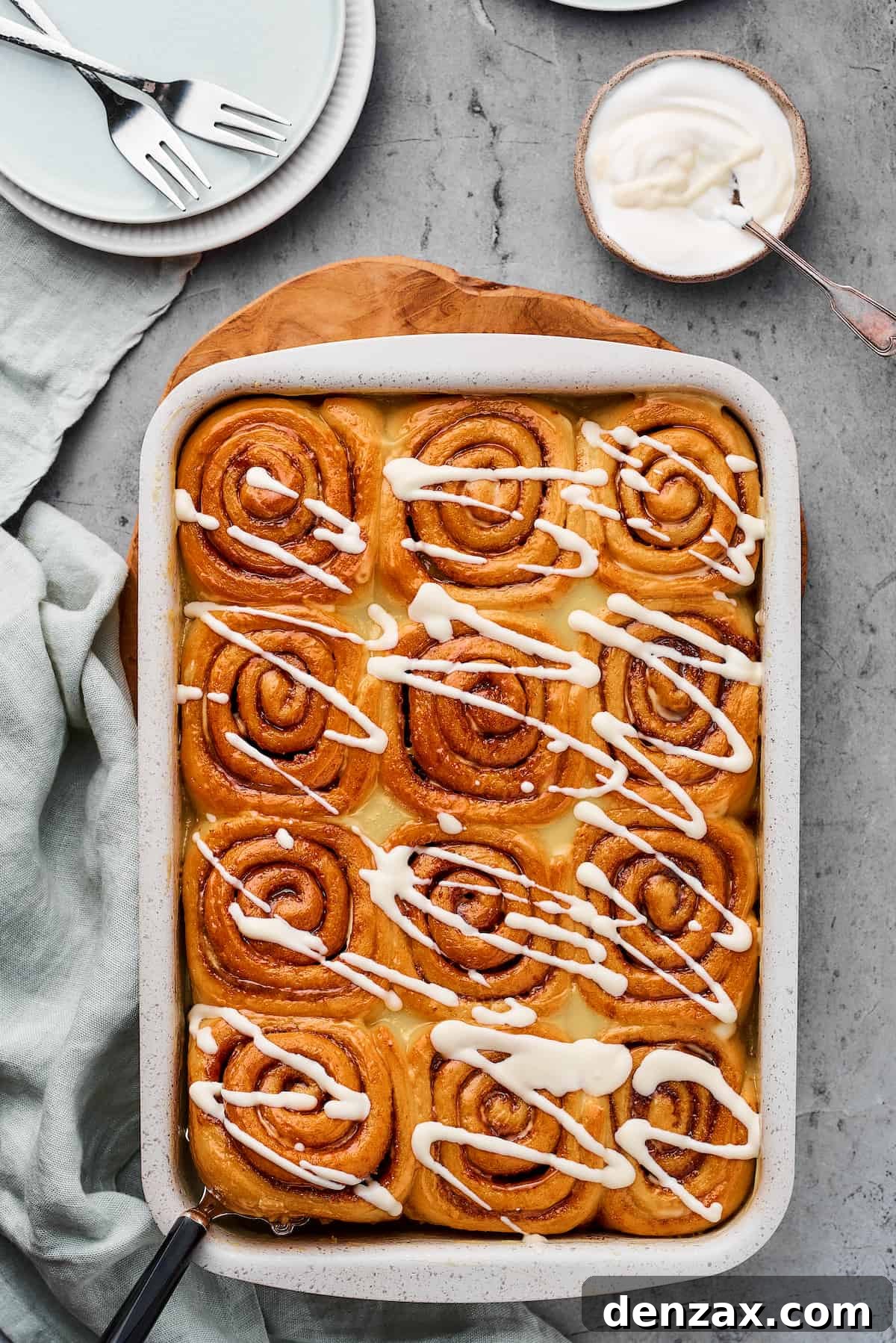 Homemade Cinnamon Rolls: Soft, Fluffy Recipe from Scratch 11 A pan of baked cinnamon rolls drizzled with icing.