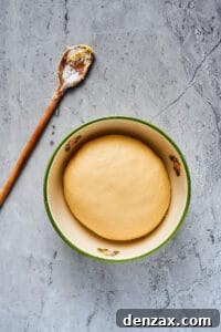 Homemade Cinnamon Rolls: Soft, Fluffy Recipe from Scratch 5 A smooth ball of dough in a large ceramic bowl.