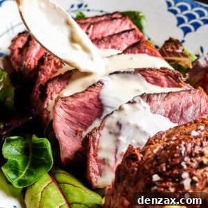 Steak slices with creamy sauce being spooned over the top.