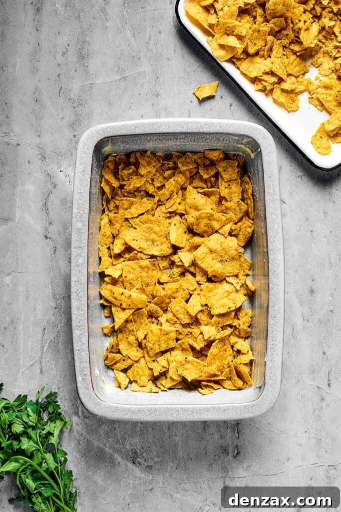 A baking dish with corn chips layered in the bottom.