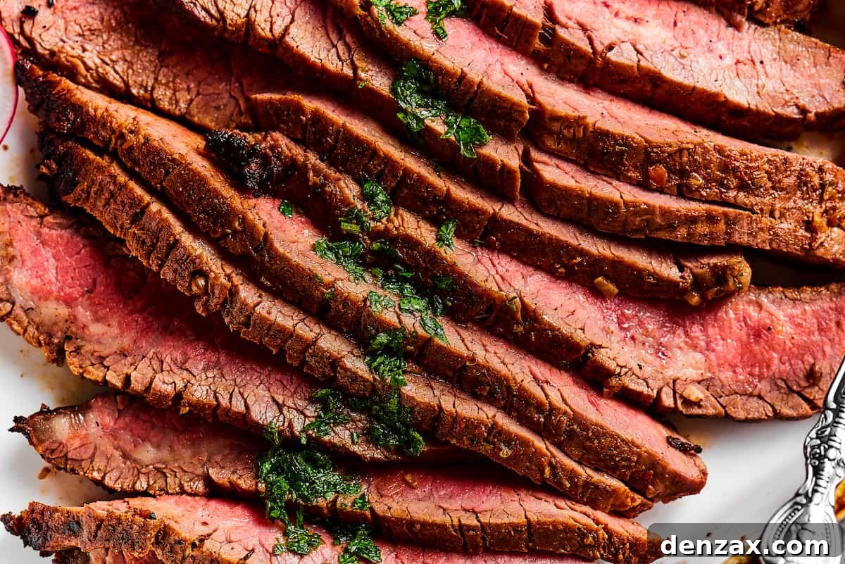 Close up shot of sliced flank steak, showing the texture and medium-rare doneness of the meat.