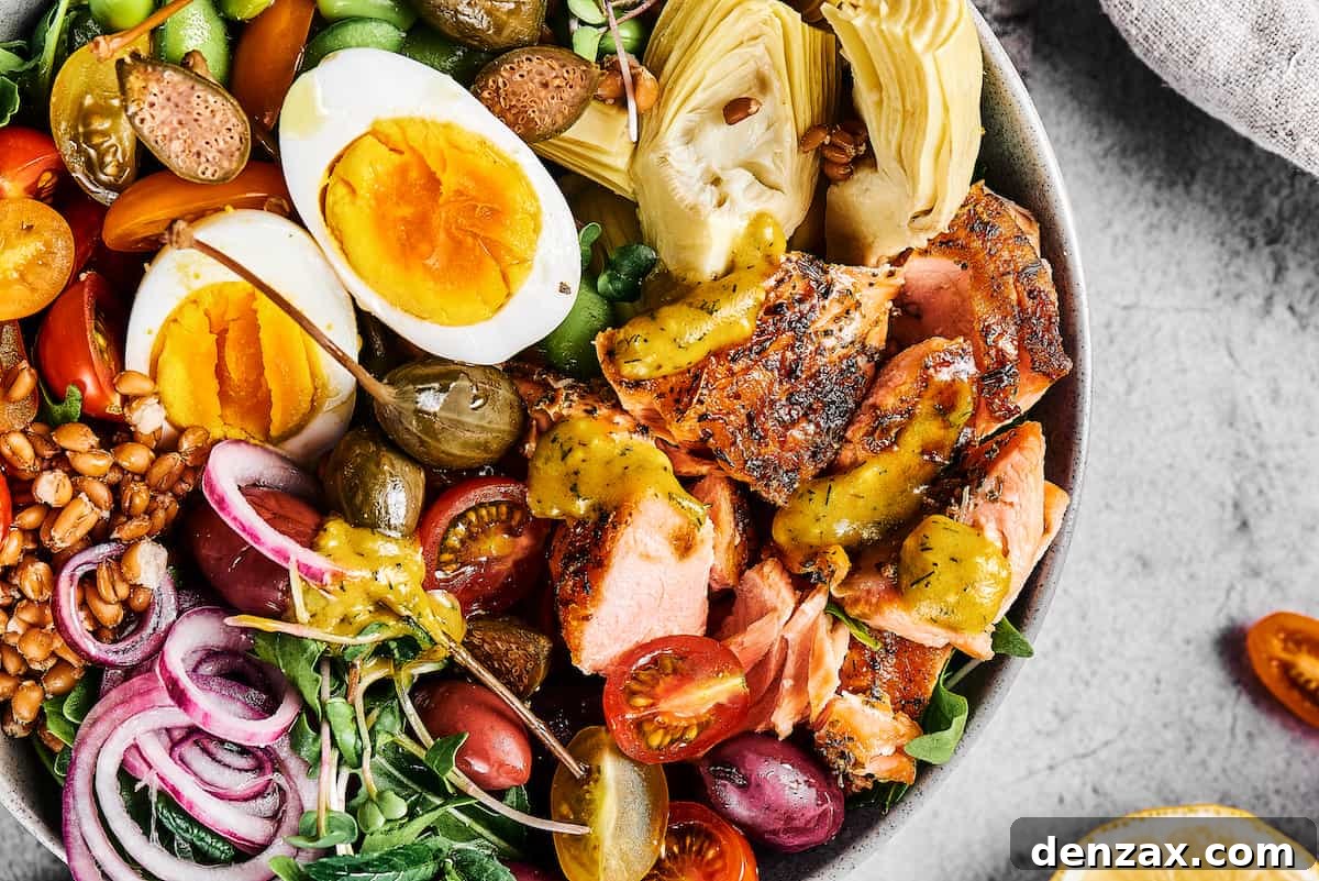 Grilled salmon salad with hard-boiled eggs, pickled red onions, halved tomatoes, and more.