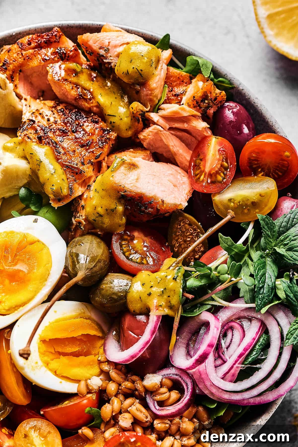 A main-course salad with grilled salmon, tomatoes, arugula, hard-boiled eggs, pickled onions, and more.