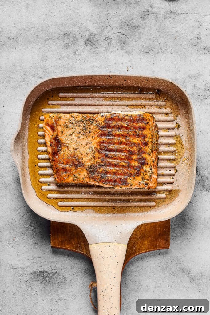 Seasoned cooked salmon on a grill pan.