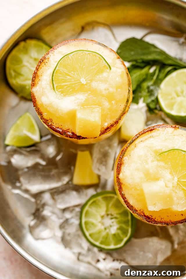 top view of frozen margaritas garnished with limes and pineapples