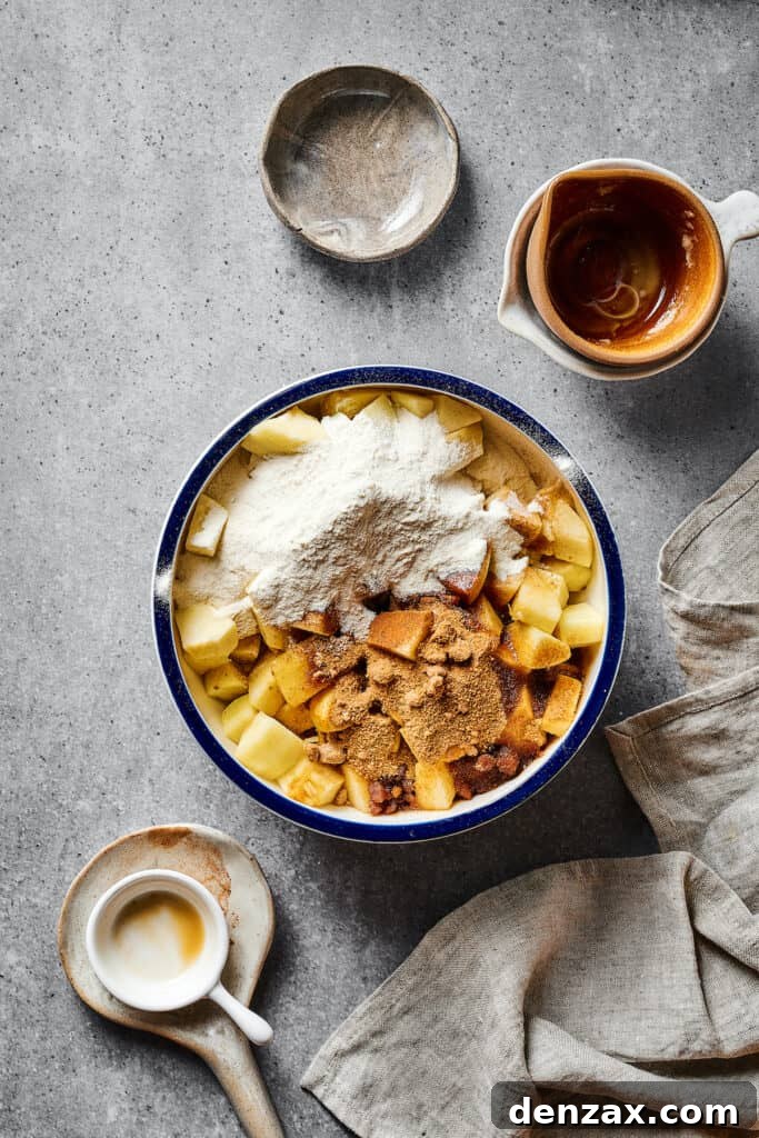A large bowl of chopped apples with flour, butter, spices, and other ingredients mixed in.