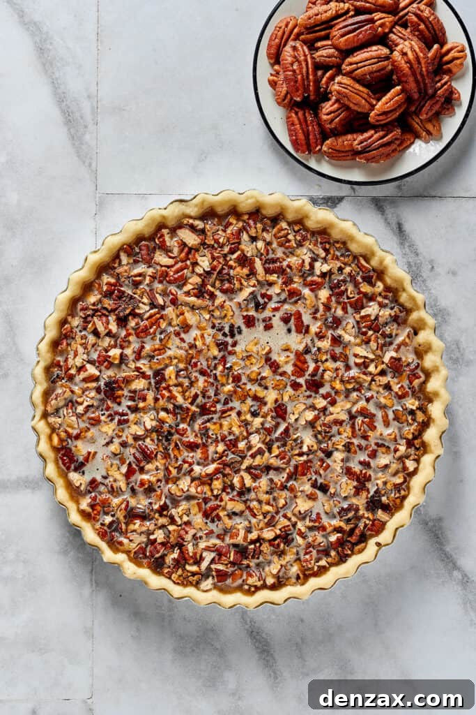 Overhead shot of a partially-assembled pecan pie. The pecan halves have not yet been added.