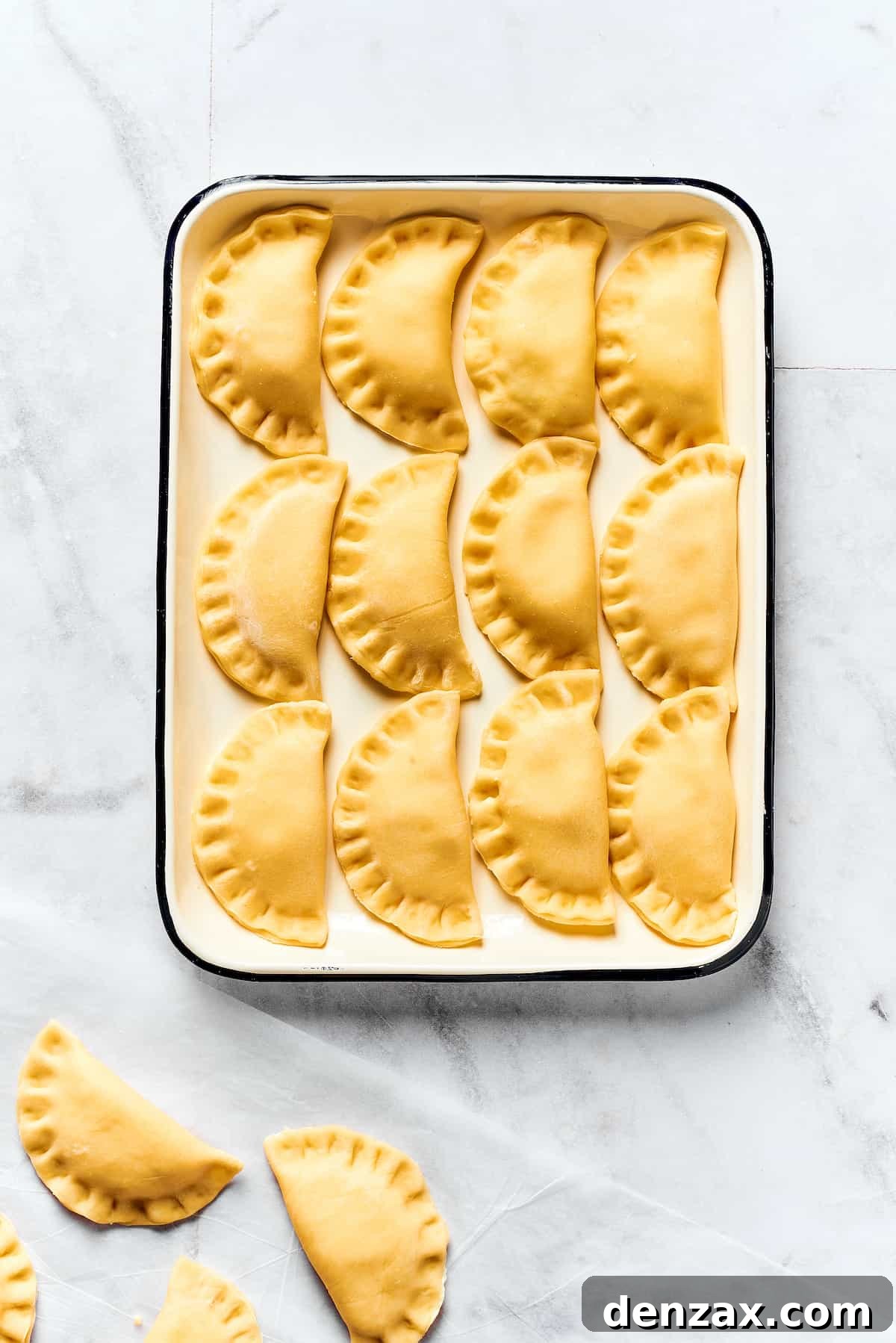 A tray of uncooked pierogies.