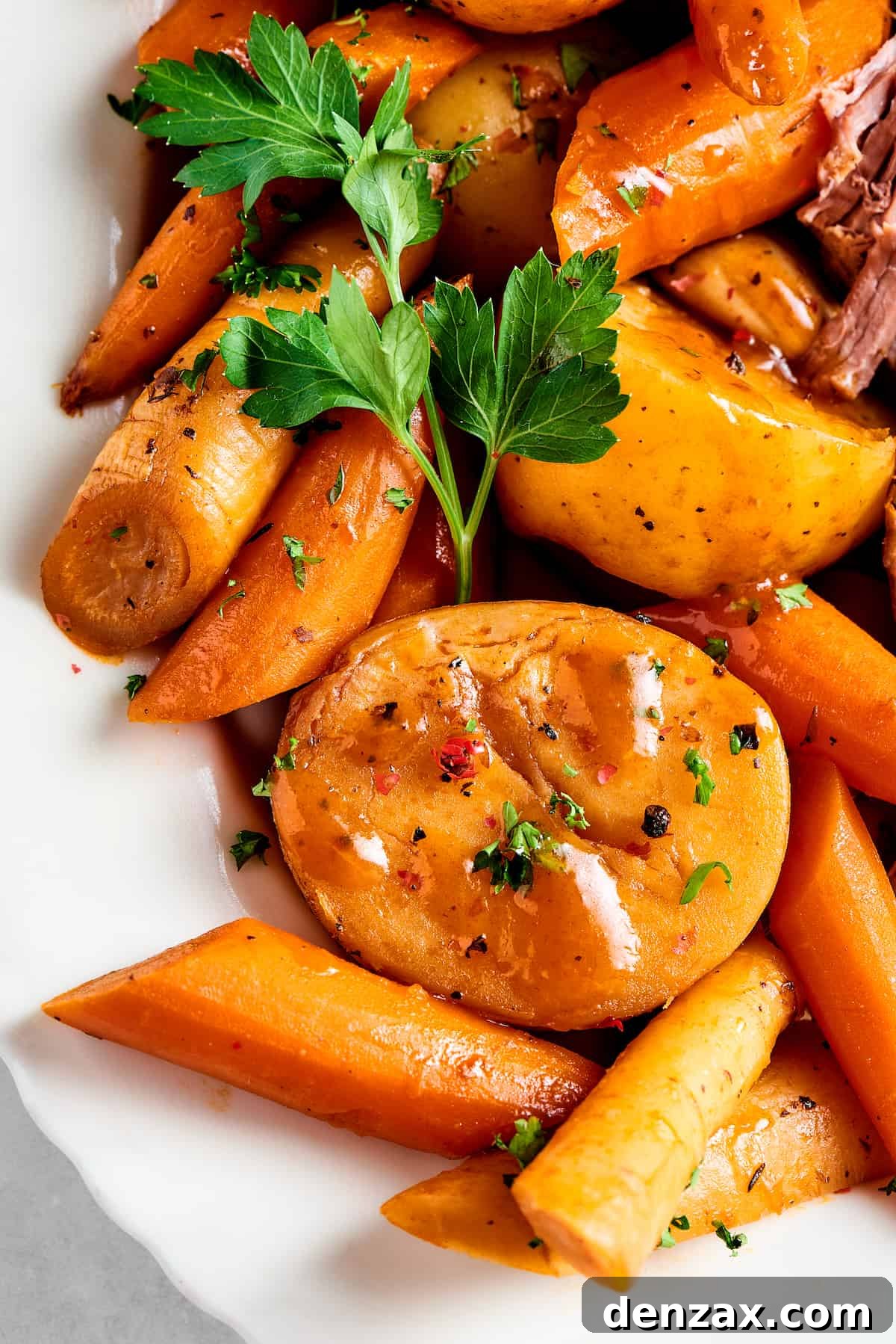 Close-up shot of cooked potatoes, carrots, and parsnips.
