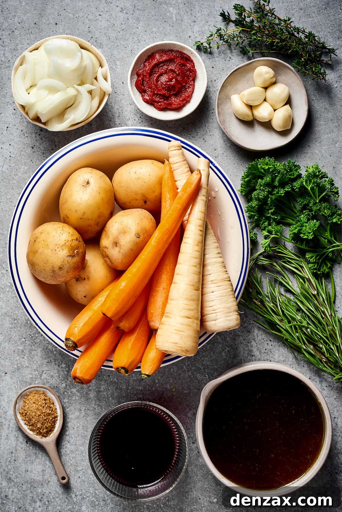 From top left: onion, tomato paste, garlic, potatoes, carrots, parsnips, fresh herbs, seasonings, red wine, beef broth.