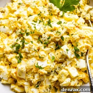 scooping out egg salad from a bowl