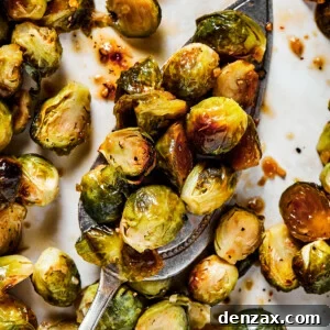 Crispy Roasted Brussels Sprouts with Balsamic Glaze 7 A tray of roasted brussel sprouts with a silver serving spoon.