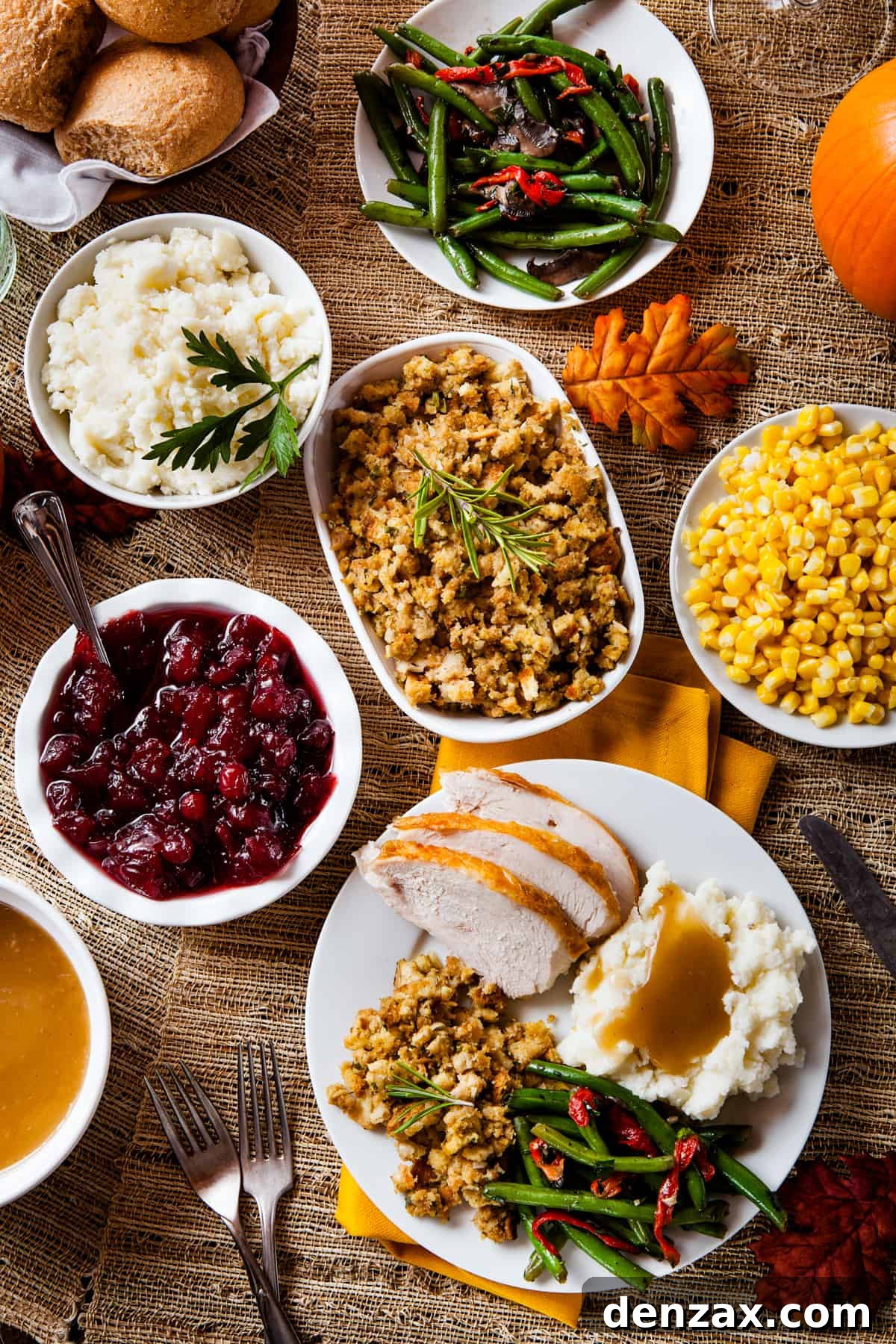 an overhead shot of a variety of serving plates filled with thanksgiving sides.