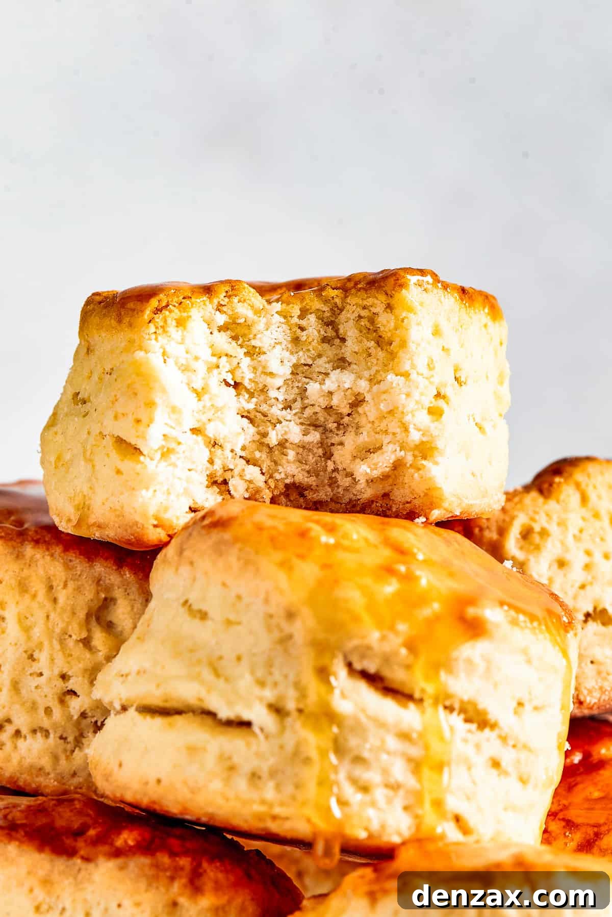 Biscuits piled onto a cake plate. One biscuit has a bite taken out of it.