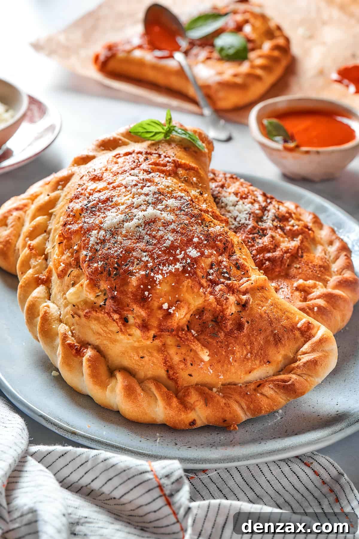 Two baked pizza pockets with crimped edges on a plate.