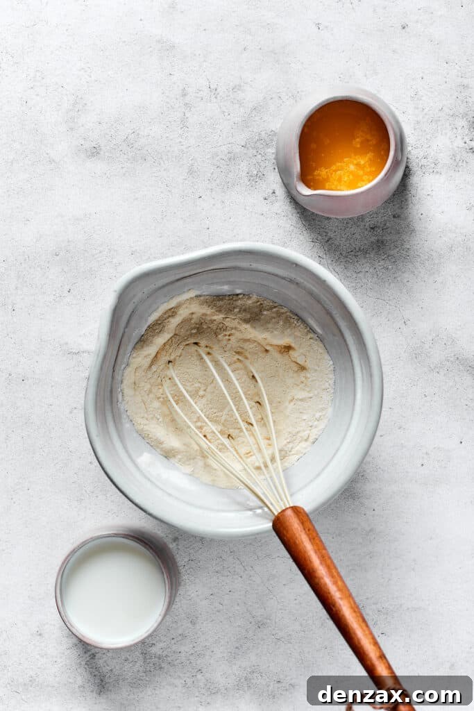 Crispy Homemade Waffles: Simple Recipe for Fluffy Breakfast 3 A small pitcher of melted butter, and a cup of buttermilk, next to a mixing bowl of waffle batter ingredients.