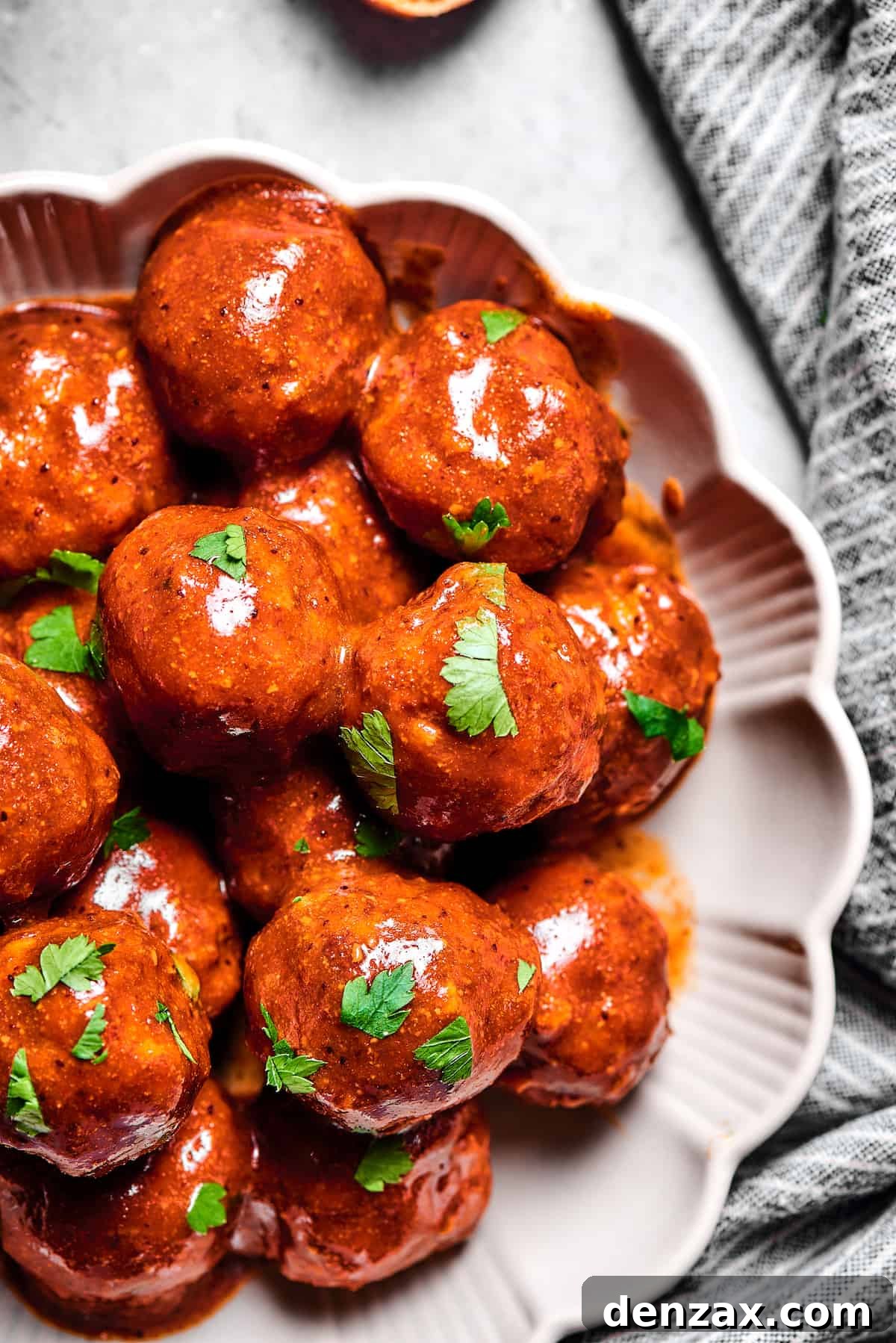 Saucy meatballs on a platter sprinkled with parsley.