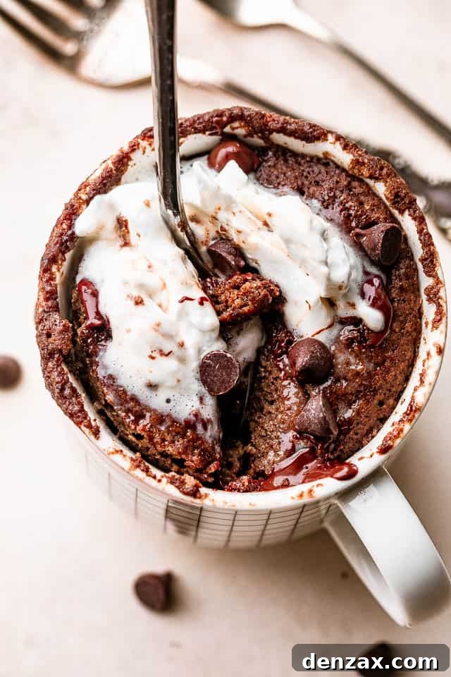 digging a spoon into a chocolate cake inside of a mug