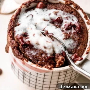 spooning out mug cake topped with whipped cream