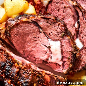 Close-up shot of prime rib, sliced and garnished with herbs.