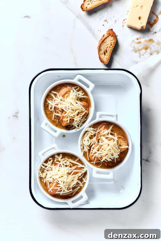 Individual bowls of soup topped with toasted baguette and shredded cheese.