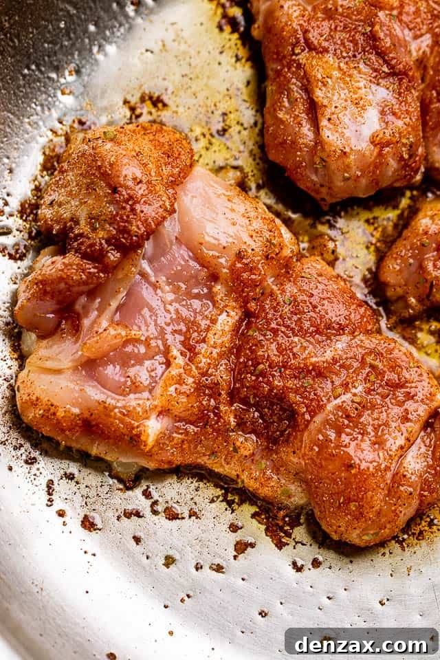 raw chicken thighs rubbed with cajun seasoning