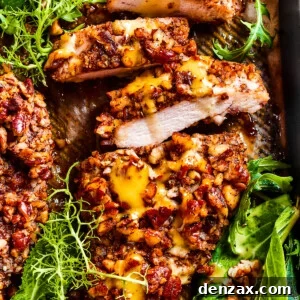 Sliced pecan chicken on a serving dish, with greens placed around the chicken.