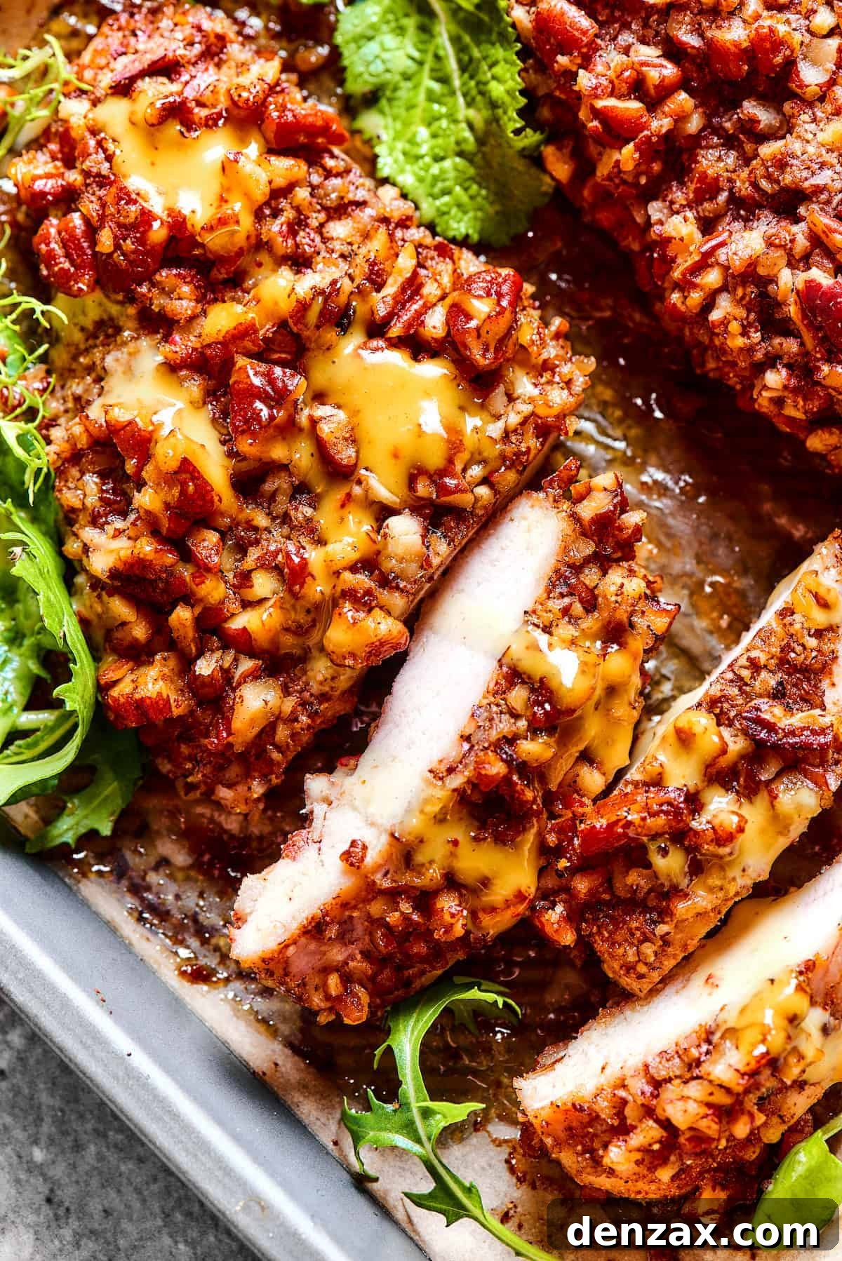 overhead photo of pecan crusted chicken, topped with honey mustard sauce, and sliced.