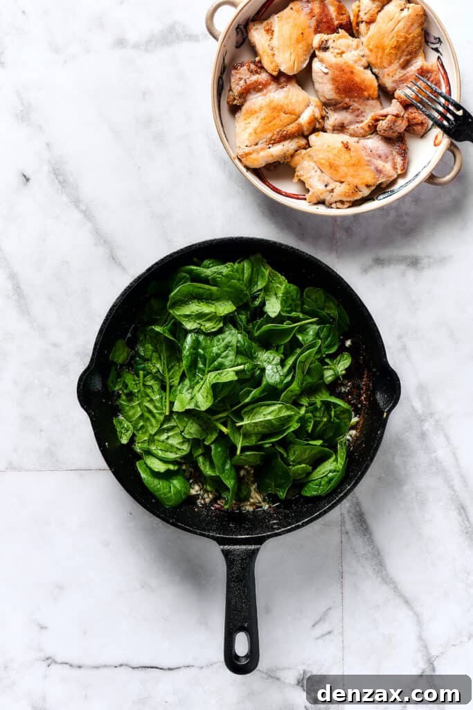 Baby spinach cooking in a skillet.