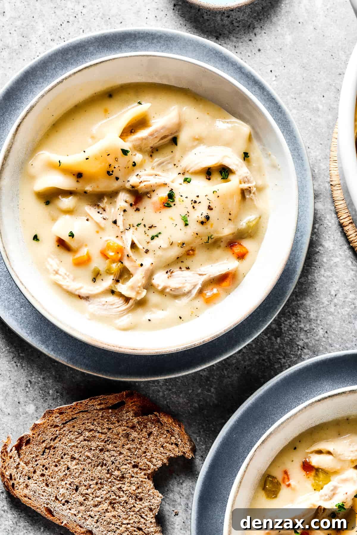 Creamy chicken and dumplings served into bowls.