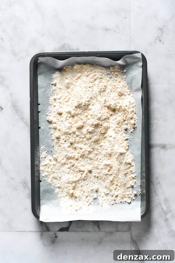 Flour spread out on a parchment-lined baking sheet.