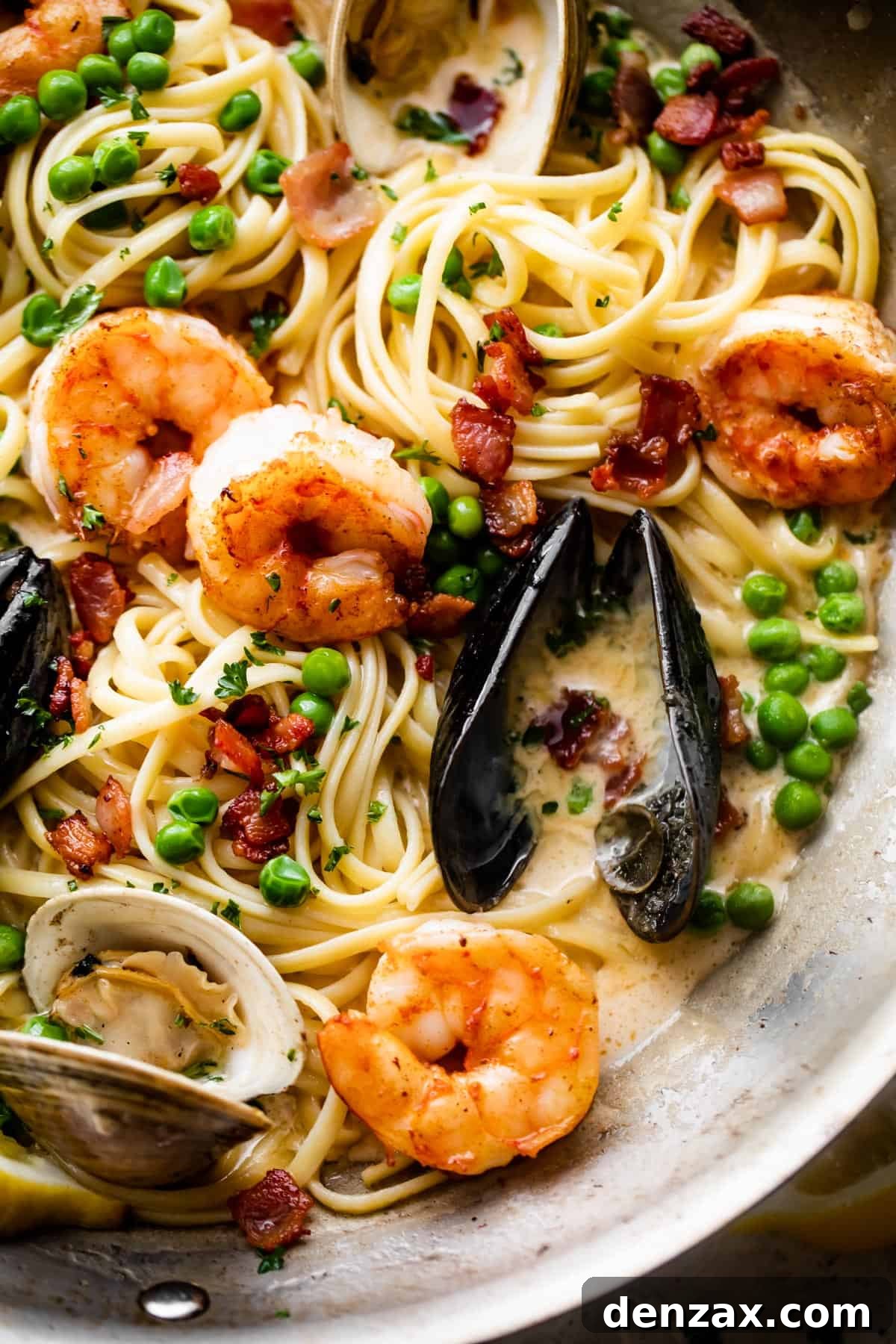 Creamy Seafood Pasta Recipe: Easy, Flavorful Weeknight Dinner 2 linguine, shrimp, mussels, bacon bits, and green peas tossed in a rich and creamy sauce.