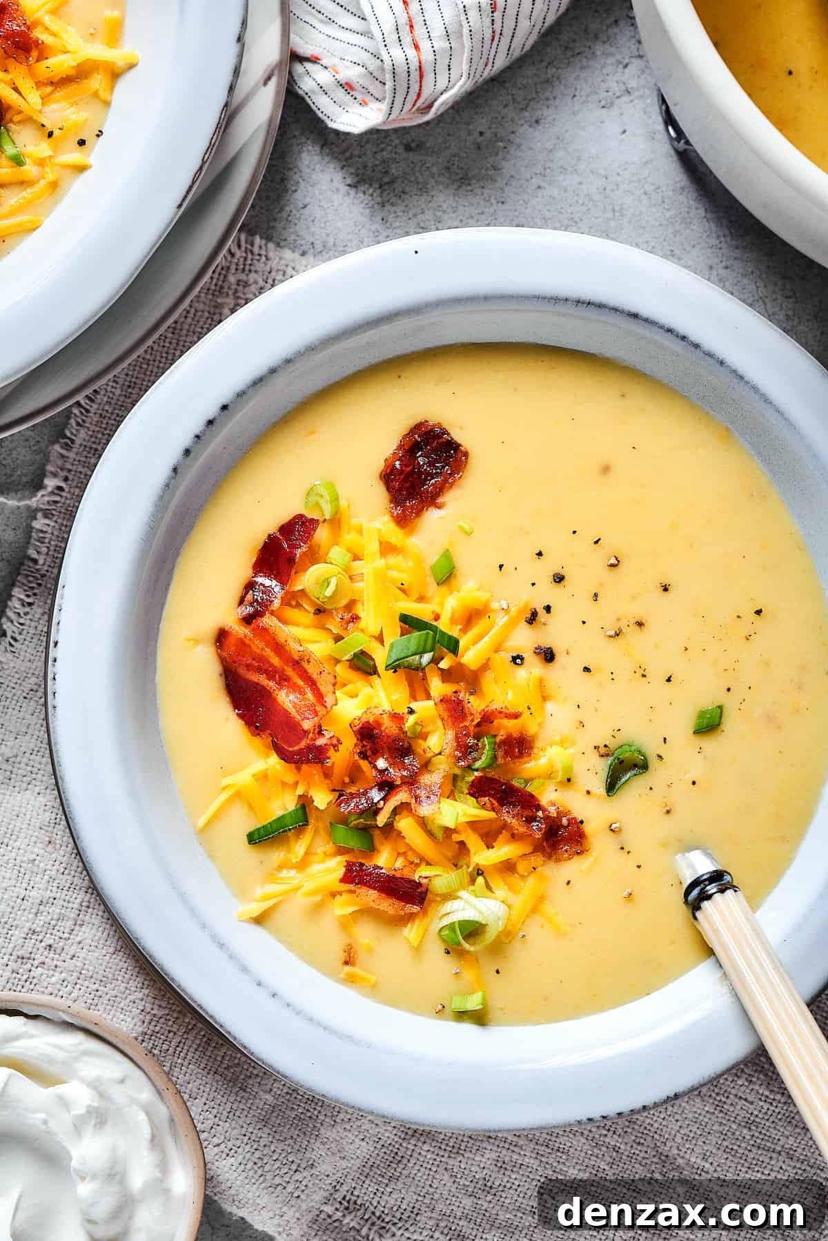Baked potato soup topped with bacon, cheese, and chopped green onion.