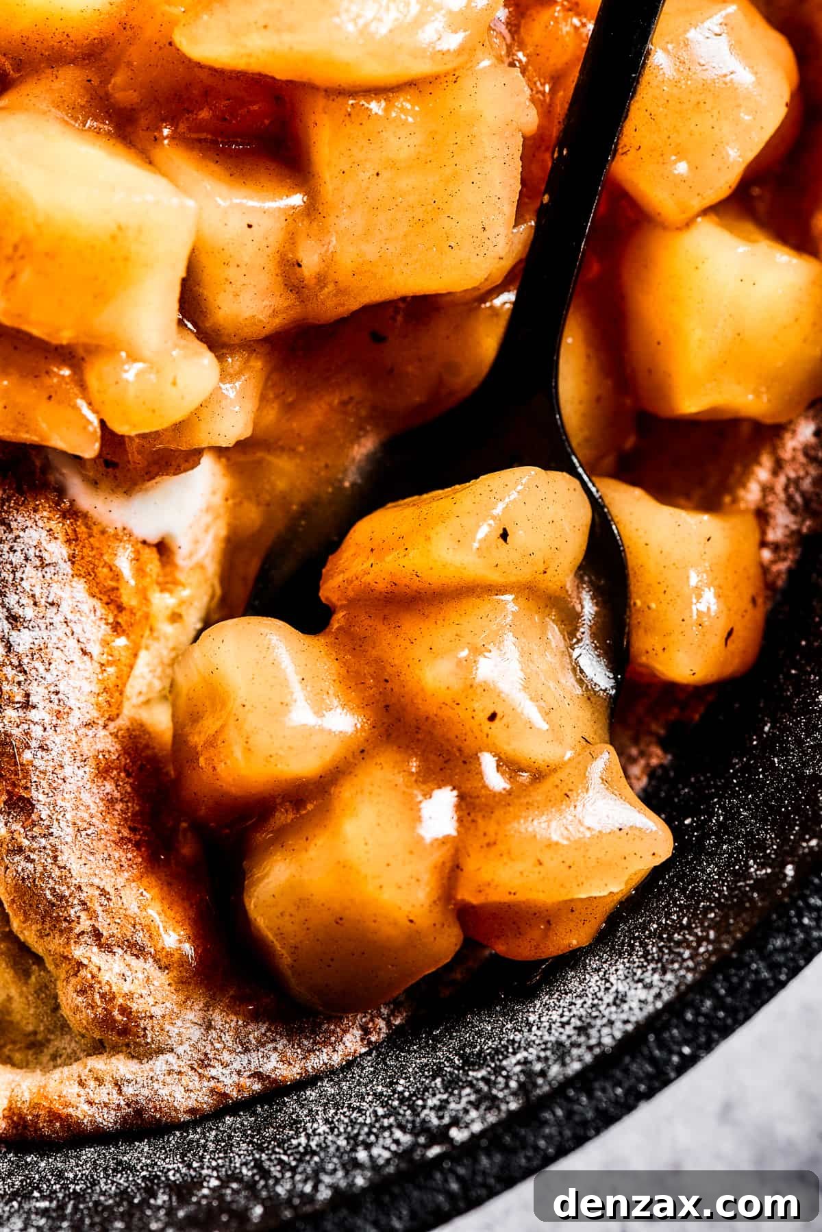 close up photo of a spoon with apple pie filling.