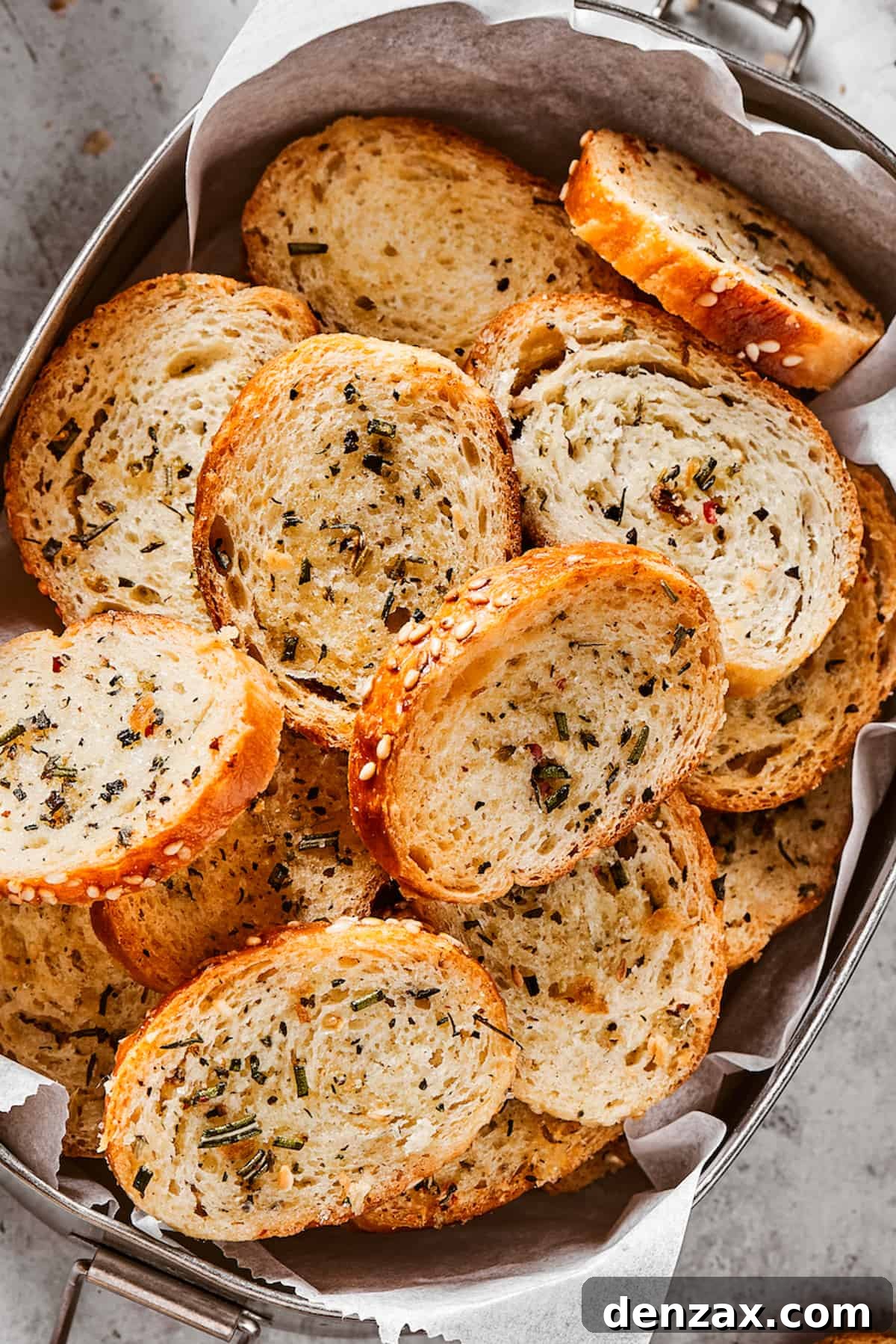 Seasoned and baked bagel chips in a metal tin.