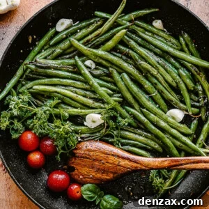 green beans, tomatoes, and garlic cloves in a black skillet with a wooden spoon inside