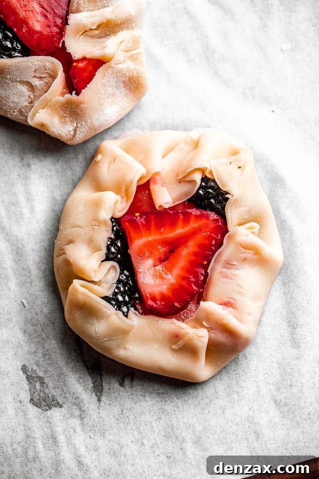 Mini berry galettes are the perfect summer dessert. Fresh berries are baked in a flaky pie crust that’s been dusted with sugar. So good! pie dough filled with berries