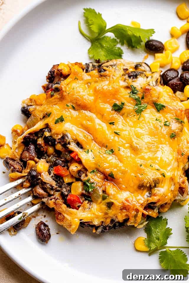 fork next to a mushroom stuffed with corn, black beans, and cheese