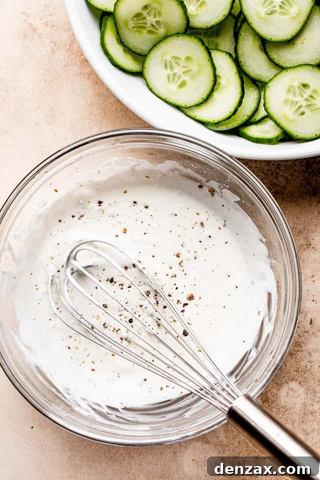 sour cream dressing in a glass bowl with a whisk inside it