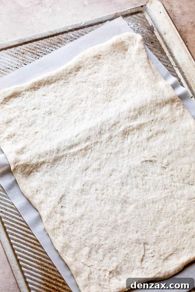 raw pizza dough on a baking sheet