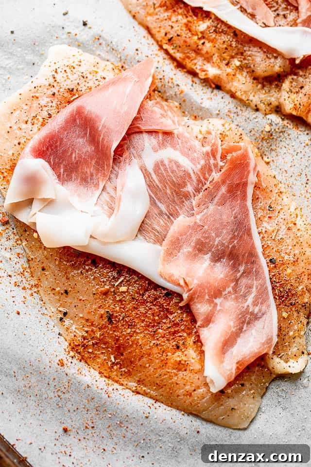 Prosciutto-Wrapped Chicken Rolls with Asparagus 4 slice of prosciutto set over a raw chicken breast
