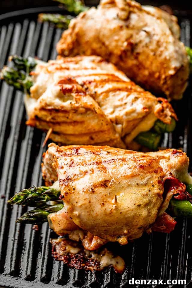 Prosciutto-Wrapped Chicken Rolls with Asparagus 6 three chicken roll ups stuffed with asparagus, prosciutto, and cheese, and cooking on a grill pan