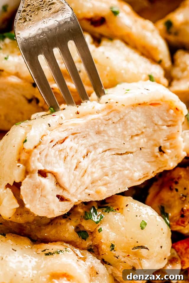 Oven-Baked Caesar Chicken with Crispy Parmesan Crust 6 close up view of a fork set through a slice of chicken breast