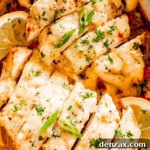 Oven-Baked Caesar Chicken with Crispy Parmesan Crust 7 close up shot of sliced baked chicken breasts topped with caesar dressing and parsley