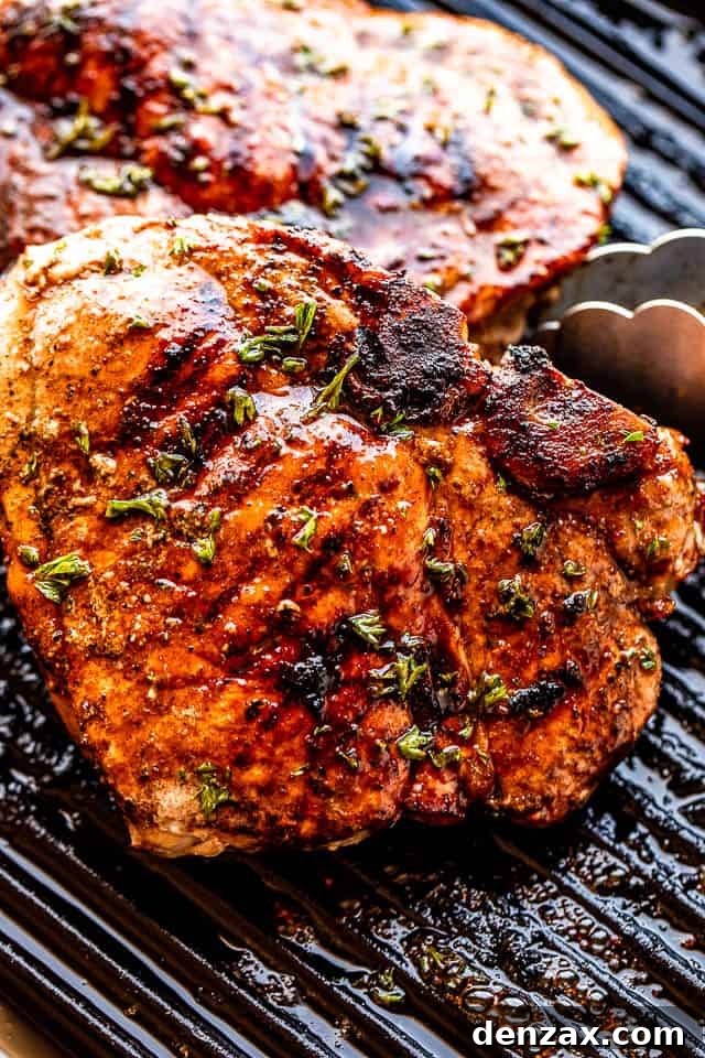 using tongs to turn over grilled pork chops