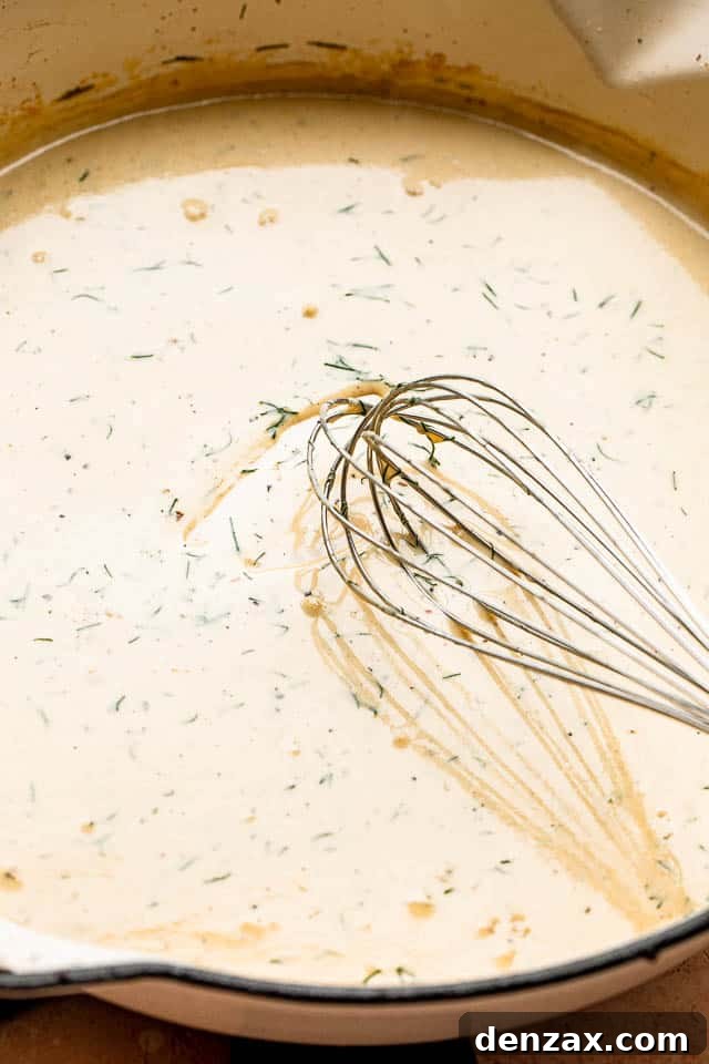 whisking a cream sauce inside a white pan