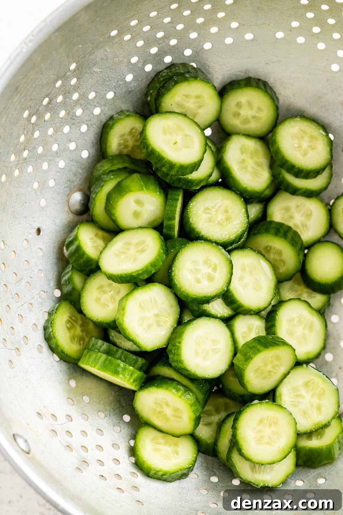 Drizzled with homemade dressing, this Jennifer Aniston quinoa salad with crunchy chickpeas is super light and refreshing. Straining the rinsed cucumbers.