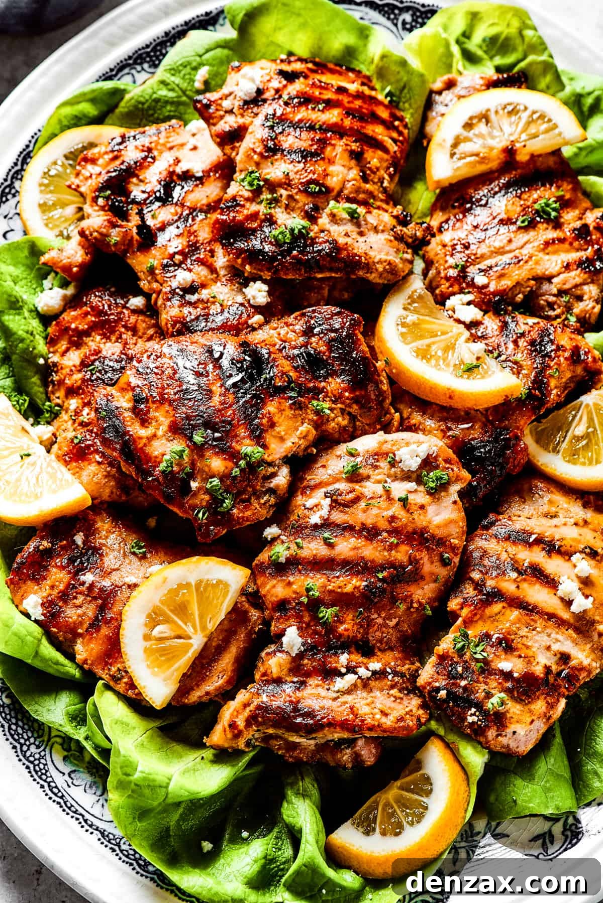 Yogurt-marinated chicken grilled set atop a bed of lettuce leaves and topped with feta cheese.