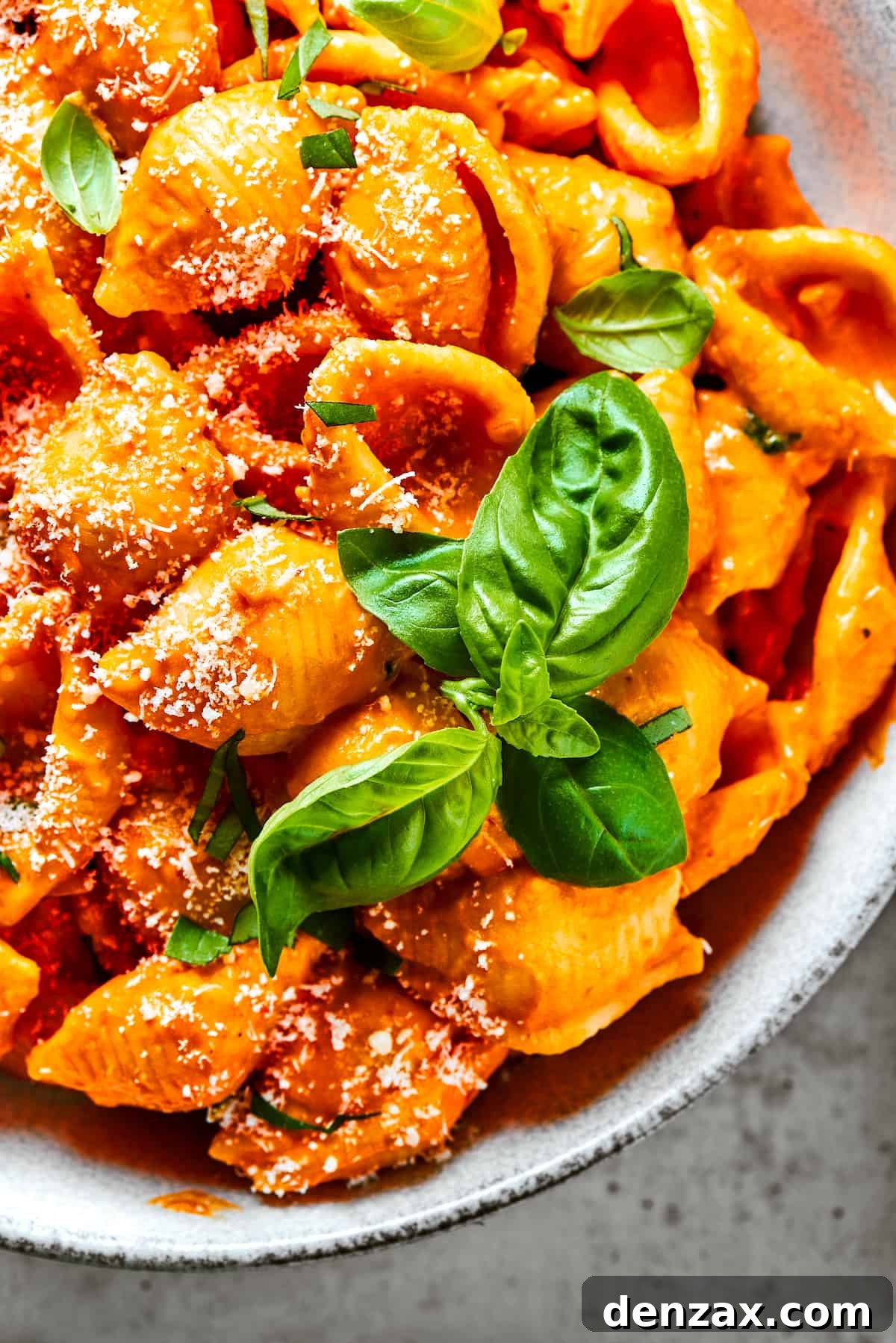 Pasta shells in creamy tomato sauce, sprinkled with parmesan.