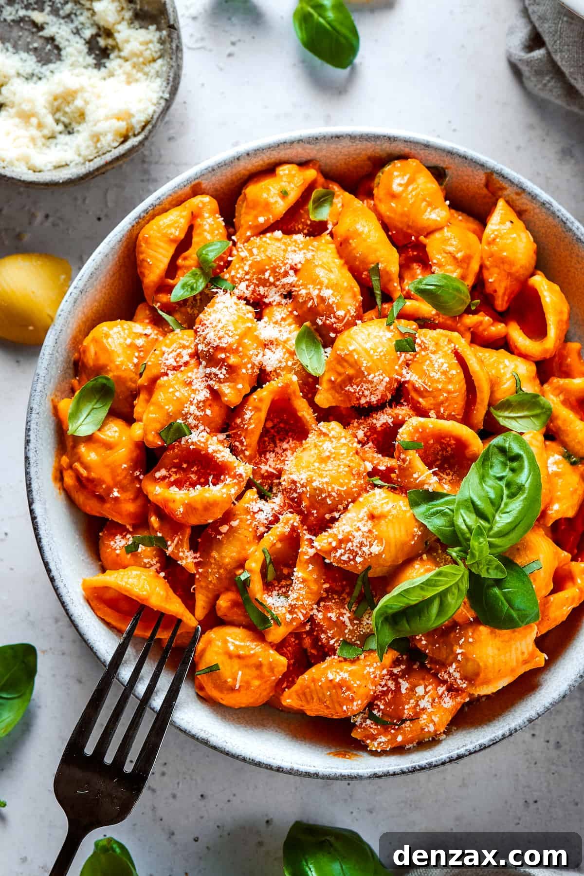 Pasta in a bowl, garnished with basil.